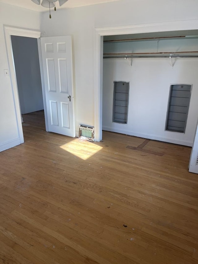 unfurnished bedroom with dark hardwood / wood-style flooring and a closet