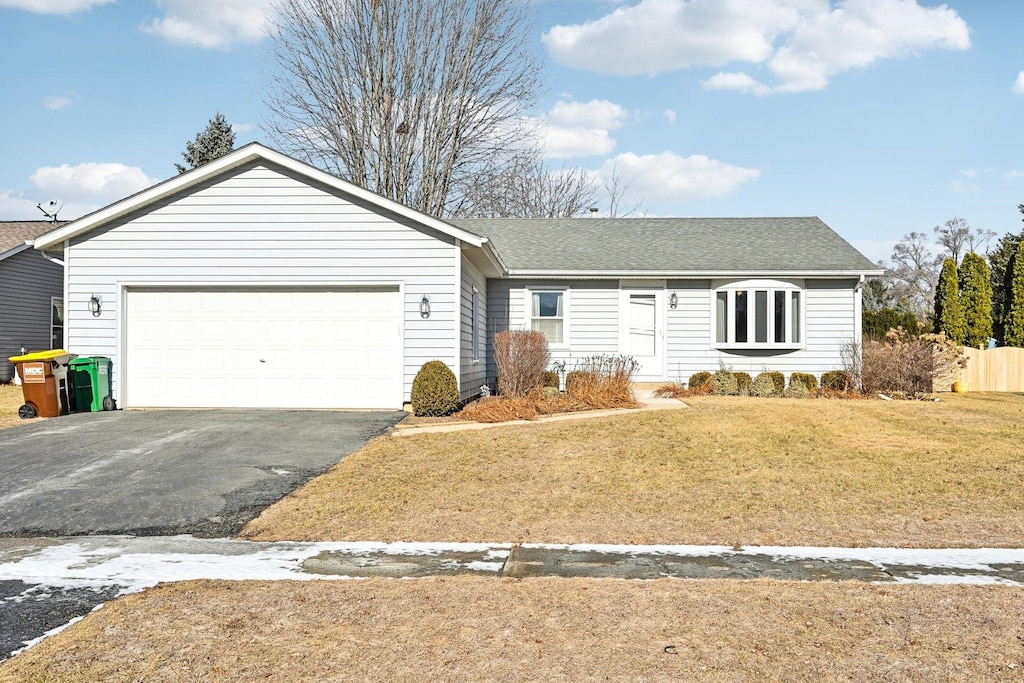 single story home featuring a garage and a front yard