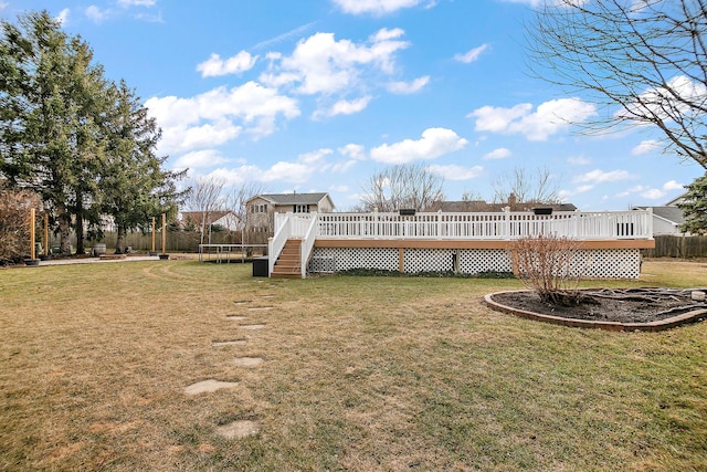 view of yard with a wooden deck and a trampoline