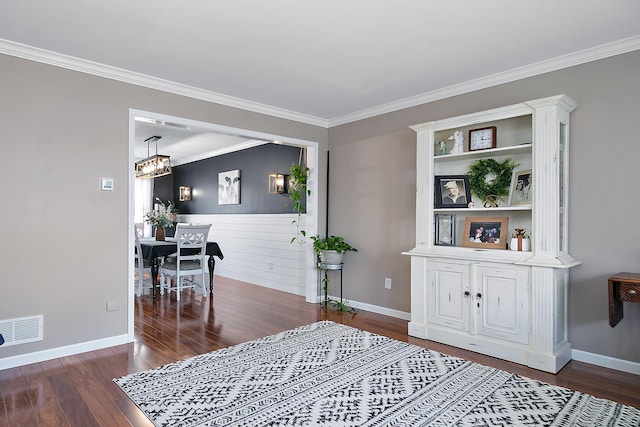 interior space featuring crown molding, dark wood-type flooring, and a chandelier