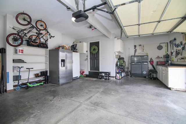 garage with a garage door opener, stainless steel fridge, and a workshop area