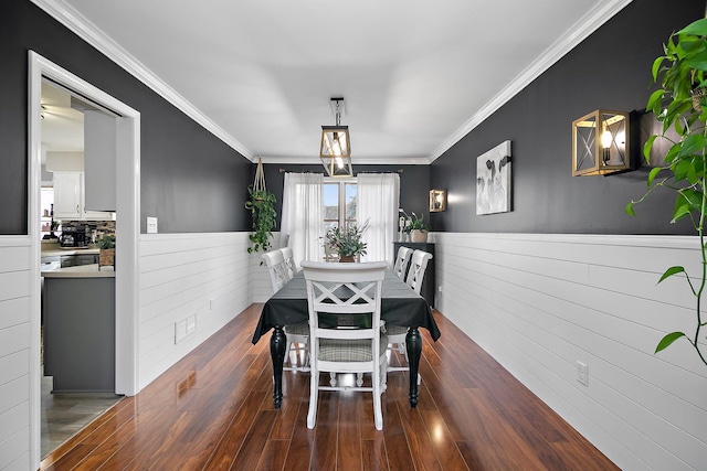 dining area featuring dark wood-type flooring and ornamental molding