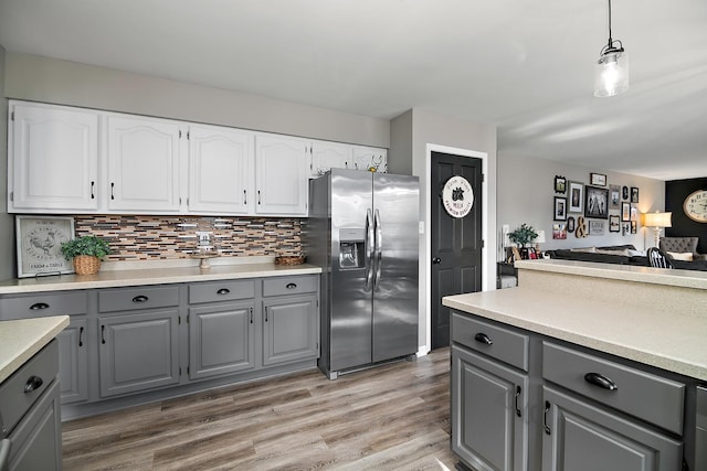 kitchen featuring pendant lighting, gray cabinets, light hardwood / wood-style flooring, white cabinetry, and stainless steel fridge with ice dispenser