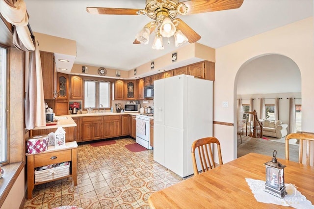 kitchen featuring ceiling fan, sink, light tile patterned flooring, and white appliances