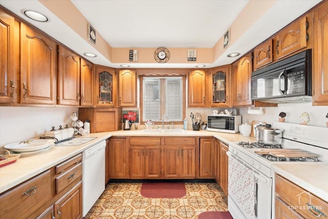 kitchen with white appliances, sink, and light tile patterned floors