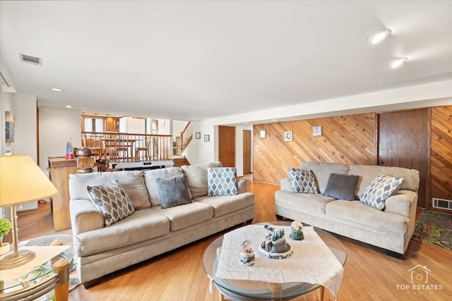 living room with wooden walls and light hardwood / wood-style floors