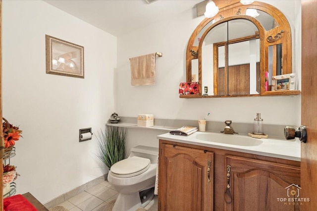 bathroom with tile patterned flooring, vanity, and toilet