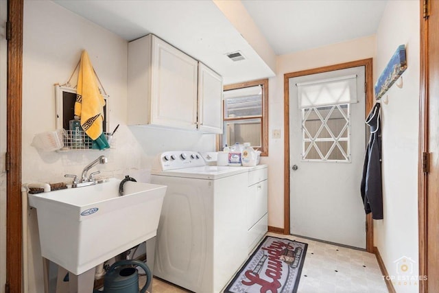 laundry room featuring independent washer and dryer, cabinets, and sink