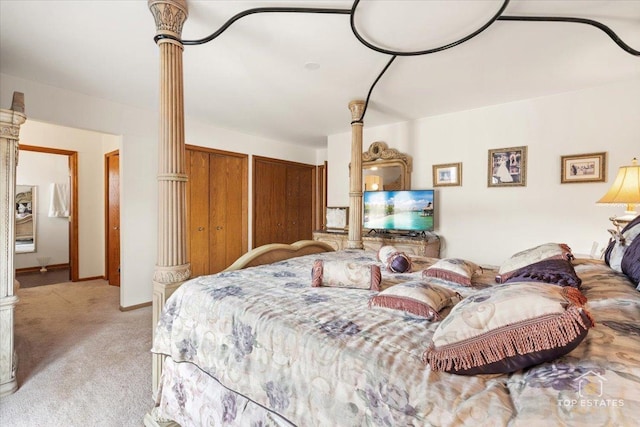 bedroom featuring light carpet, decorative columns, and multiple closets