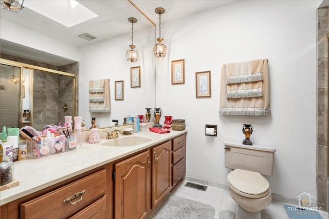 bathroom with toilet, an enclosed shower, a skylight, vanity, and tile patterned flooring