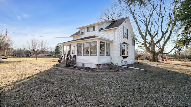 view of front of home with a front lawn and a sunroom