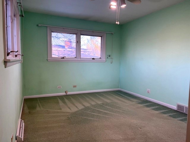 spare room with ceiling fan and carpet