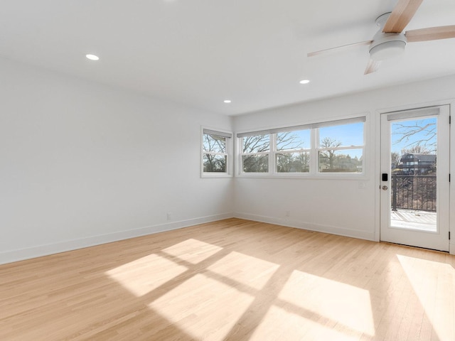 unfurnished room with ceiling fan, a healthy amount of sunlight, and light wood-type flooring