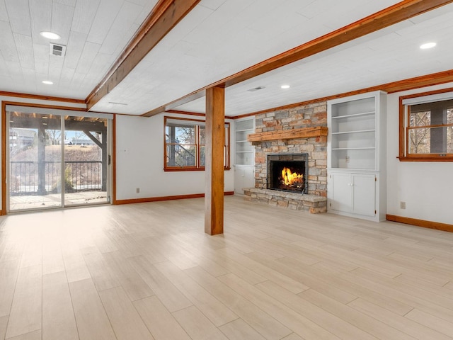 unfurnished living room with beamed ceiling, built in shelves, a fireplace, and light hardwood / wood-style flooring