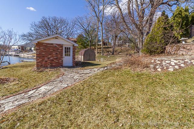 view of yard featuring a shed and a water view