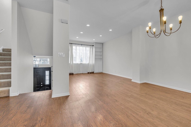 unfurnished living room featuring hardwood / wood-style flooring and a notable chandelier