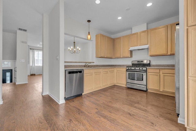 kitchen with appliances with stainless steel finishes, wood-type flooring, and light brown cabinets