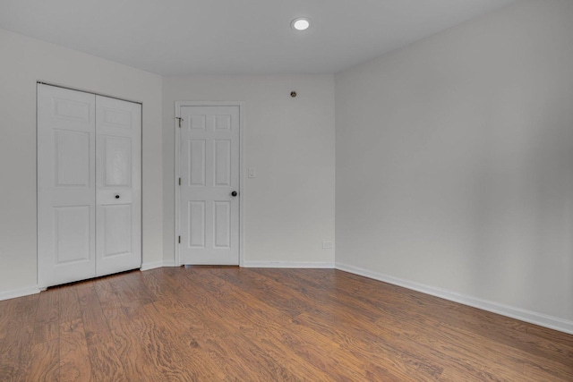 unfurnished bedroom with hardwood / wood-style floors and a closet