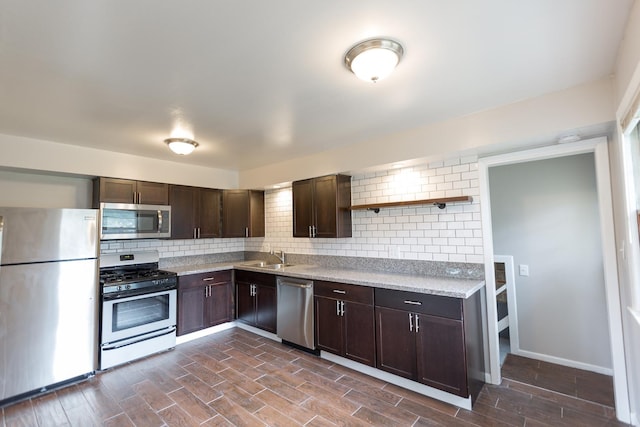 kitchen with dark brown cabinetry, sink, tasteful backsplash, and stainless steel appliances