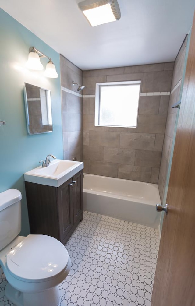 full bathroom with vanity, toilet, and tiled shower / bath combo