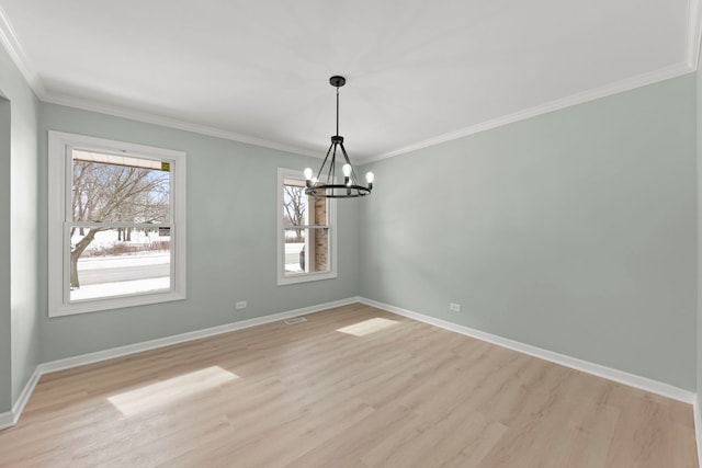 empty room featuring an inviting chandelier, ornamental molding, and light wood-type flooring