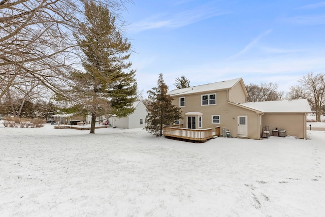 snow covered rear of property featuring a wooden deck