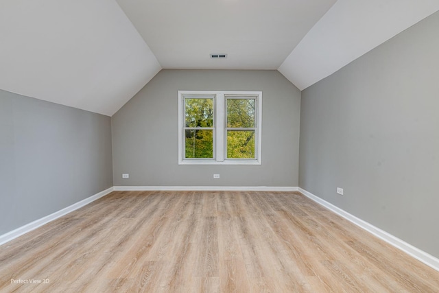 additional living space featuring vaulted ceiling and light hardwood / wood-style flooring