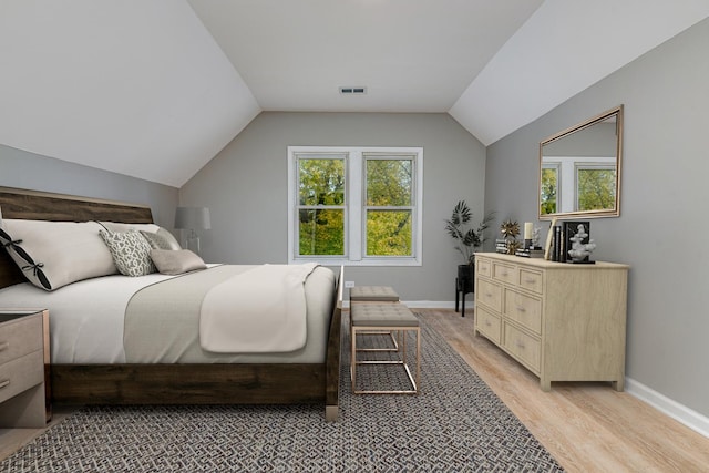 bedroom featuring lofted ceiling and light wood-type flooring