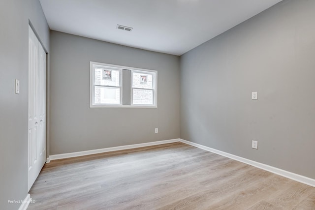 unfurnished bedroom with a closet and light wood-type flooring