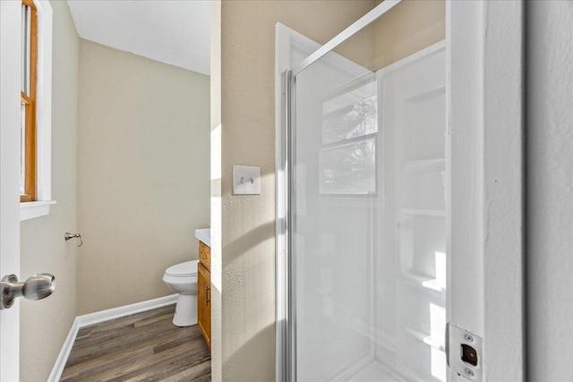 bathroom featuring an enclosed shower, vanity, hardwood / wood-style flooring, and toilet