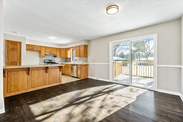 kitchen with light hardwood / wood-style flooring, stainless steel appliances, kitchen peninsula, and a breakfast bar