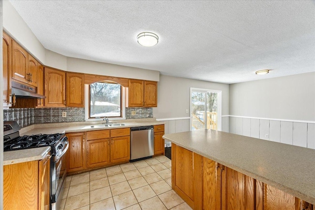 kitchen with sink, light tile patterned floors, a wealth of natural light, and stainless steel appliances