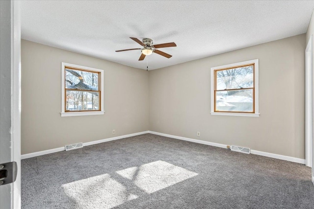 empty room with ceiling fan, carpet floors, and a textured ceiling