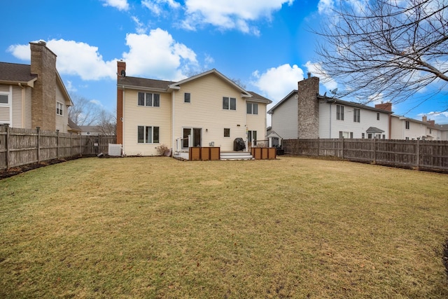 back of property with a deck and a lawn