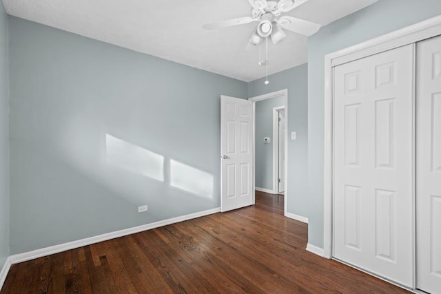 unfurnished bedroom with dark wood-type flooring, ceiling fan, and a closet