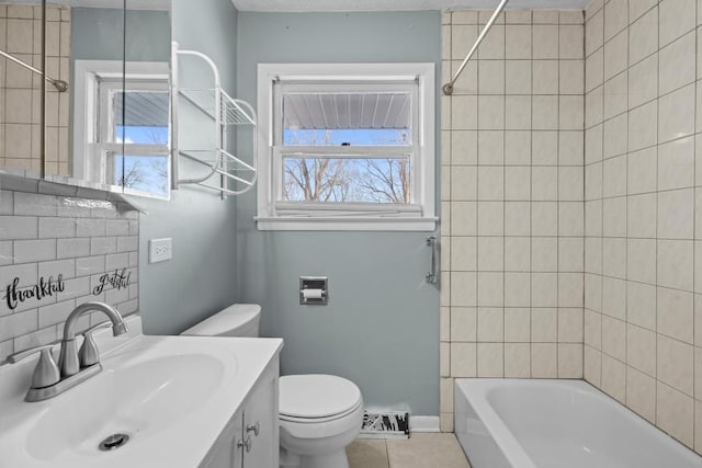 full bathroom with tiled shower / bath combo, vanity, tile patterned floors, and toilet