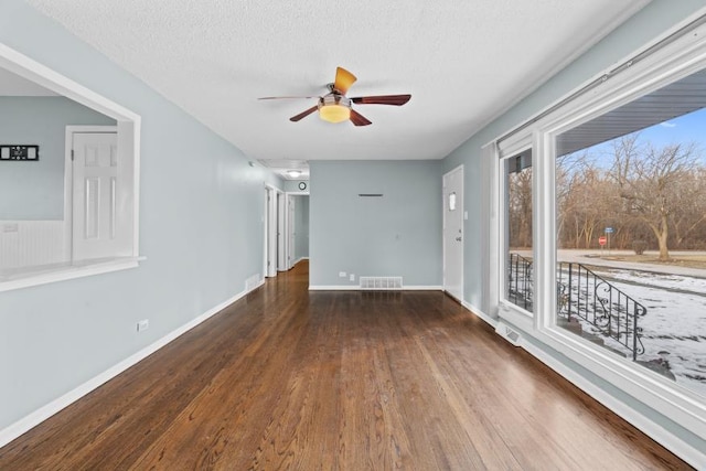 unfurnished room with ceiling fan, dark hardwood / wood-style floors, and a textured ceiling