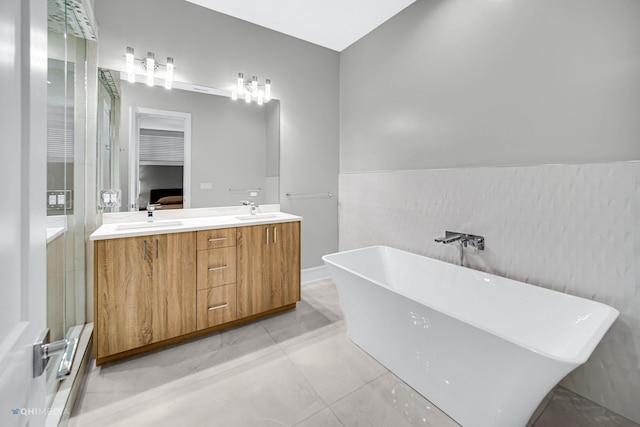 bathroom featuring vanity, a tub to relax in, and tile patterned floors