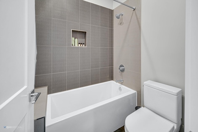 bathroom featuring toilet and tiled shower / bath combo