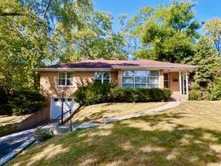 single story home featuring a garage and a front lawn