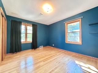 spare room with lofted ceiling, light hardwood / wood-style flooring, and a healthy amount of sunlight