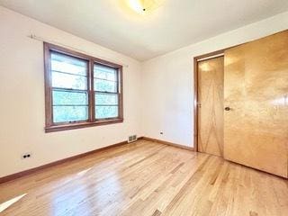 unfurnished bedroom featuring a closet and light wood-type flooring