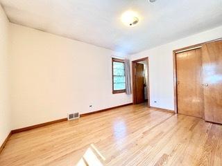 unfurnished bedroom featuring light hardwood / wood-style floors and a closet