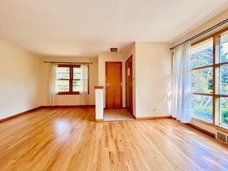 unfurnished living room featuring plenty of natural light and light hardwood / wood-style flooring