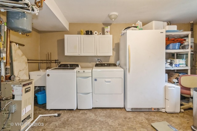 laundry area featuring cabinets, washing machine and dryer, and sink