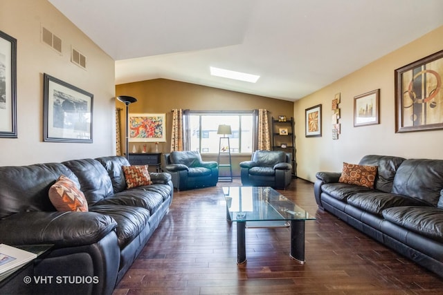 living room featuring dark hardwood / wood-style floors and vaulted ceiling with skylight