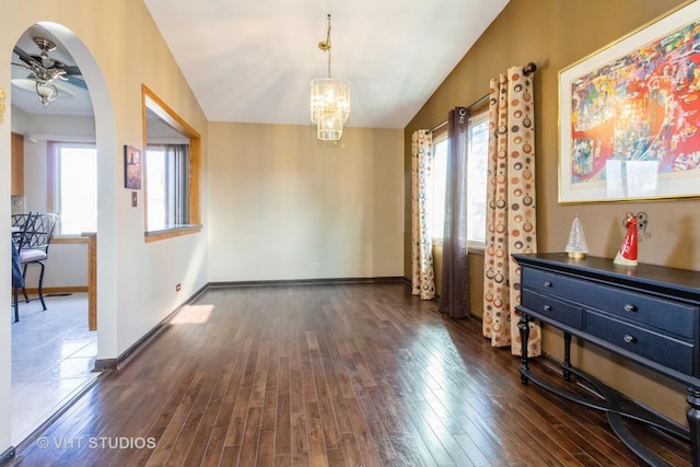 interior space featuring an inviting chandelier, lofted ceiling, and dark hardwood / wood-style floors