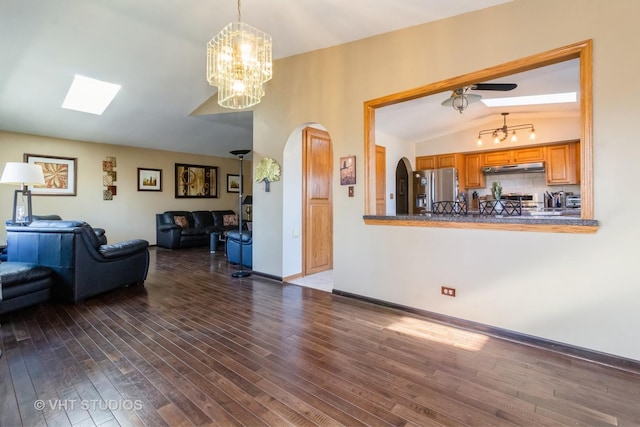 living room with lofted ceiling, ceiling fan with notable chandelier, and dark hardwood / wood-style floors