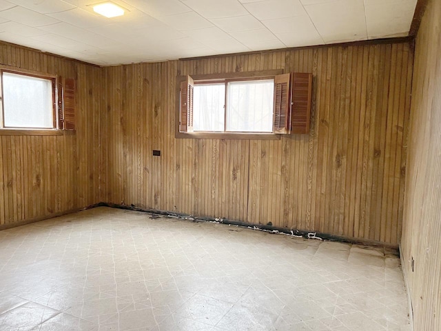 empty room with plenty of natural light and wooden walls