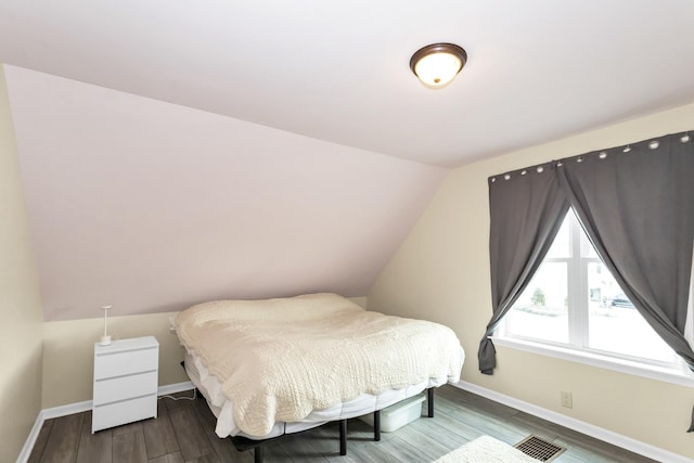 bedroom featuring hardwood / wood-style floors and vaulted ceiling